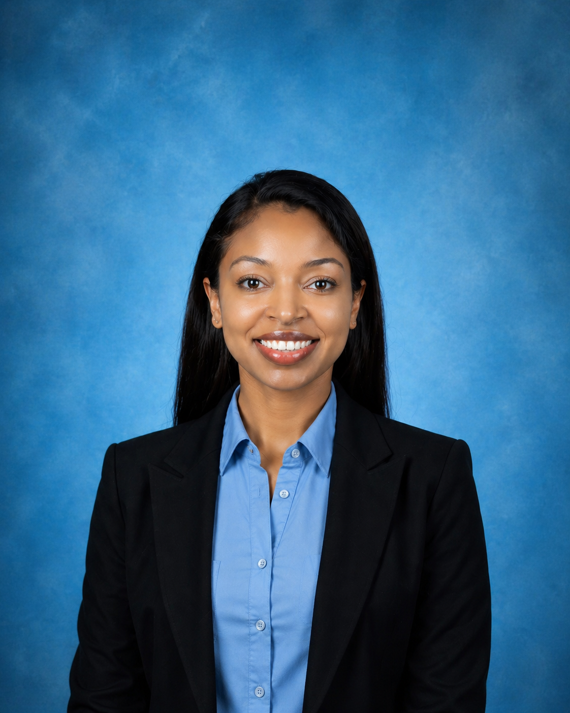 Dr. Tyler Taylor, smiling in a black blazer and light blue shirt against a blue background.